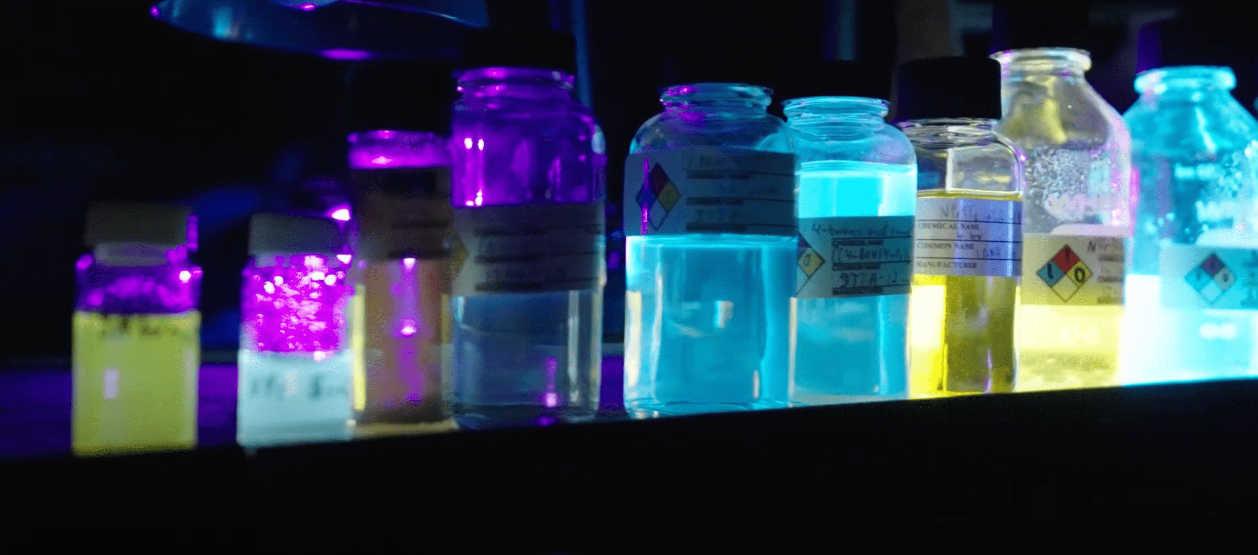 Beakers of different neon colors of fluids on a bench